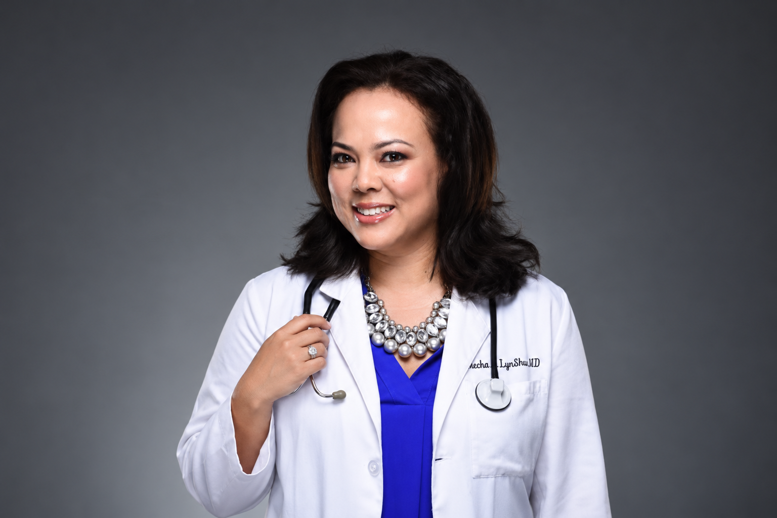 Dr. Kecha A LynShue smiling, with her right hand resting on her stethoscope